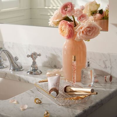 Goldleaf Gardenia Eau de Parfum featured on bathroom countertop next to flower vase and Goldleaf Gardenia products